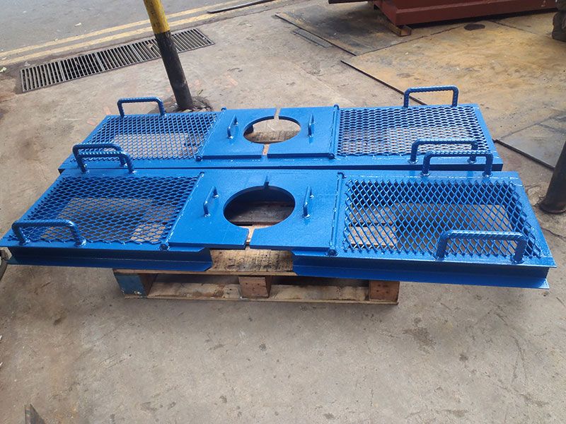 Two blue mesh-panelled steel plates with lifting handles, on a pallet